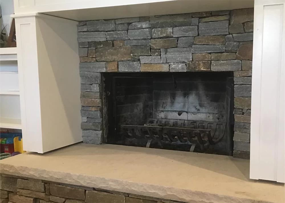 Stacked stone veneer fireplace refacing installation in Clermont, FL by Aesthetic Tile
